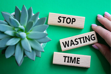 Stop Wasting Time symbol. Wooden blocks with words Stop Wasting Time. Beautiful green background....