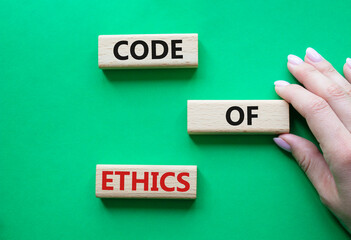 Code of ethics symbol. Concept words Code of ethics on wooden blocks. Beautiful green background....