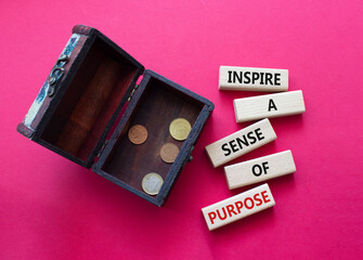 Purpose symbol. Wooden blocks with words Inspire a sense of Purpose. Beautiful red background with money box. Business and Purpose concept. Copy space.