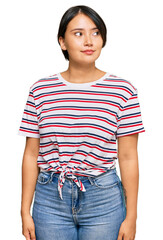 Fototapeta premium Beautiful young woman with short hair wearing casual clothes smiling looking to the side and staring away thinking.
