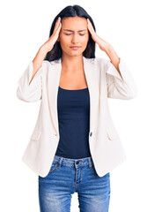 Young beautiful latin girl wearing business clothes suffering from headache desperate and stressed because pain and migraine. hands on head.