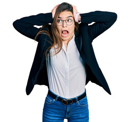 Young caucasian girl wearing business style and glasses crazy and scared with hands on head, afraid...