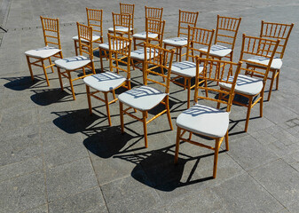 Sunny seating. A parade of 15 chairs in the town square. Light and shadow. Pattern and texture.