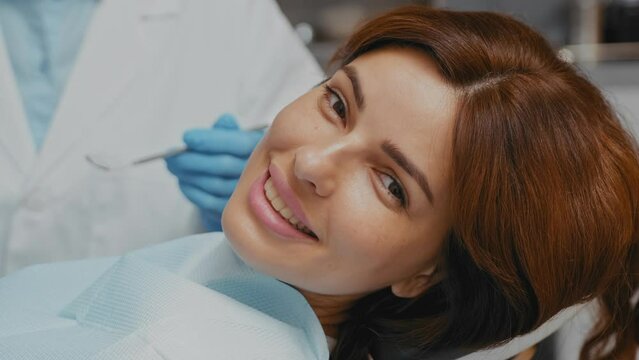 Beautiful Smiling Woman in Dentist Chair: Close-up Shot with Sparkling Teeth