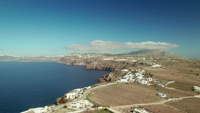 White greek island vilages by the sea with mountains on the horizon drone view