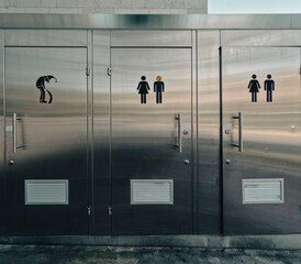 Bathroom Stall Humor. Public bathroom stalls in Basel, Switzerland. Humorous icons on the front of each stall door for men, woman and wizards. - obrazy, fototapety, plakaty