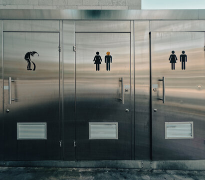 Bathroom Stall Humor. Public bathroom stalls in Basel, Switzerland. Humorous icons on the front of each stall door for men, woman and wizards.