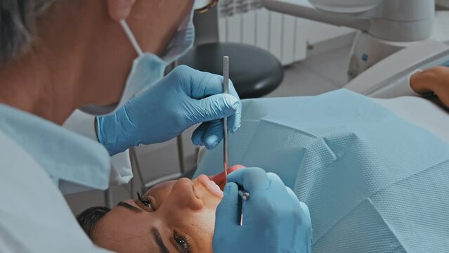 Dentist Conducting Teeth Examination on Woman: Close-up Focus
