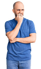 Young handsome man wearing casual t shirt looking stressed and nervous with hands on mouth biting nails. anxiety problem.