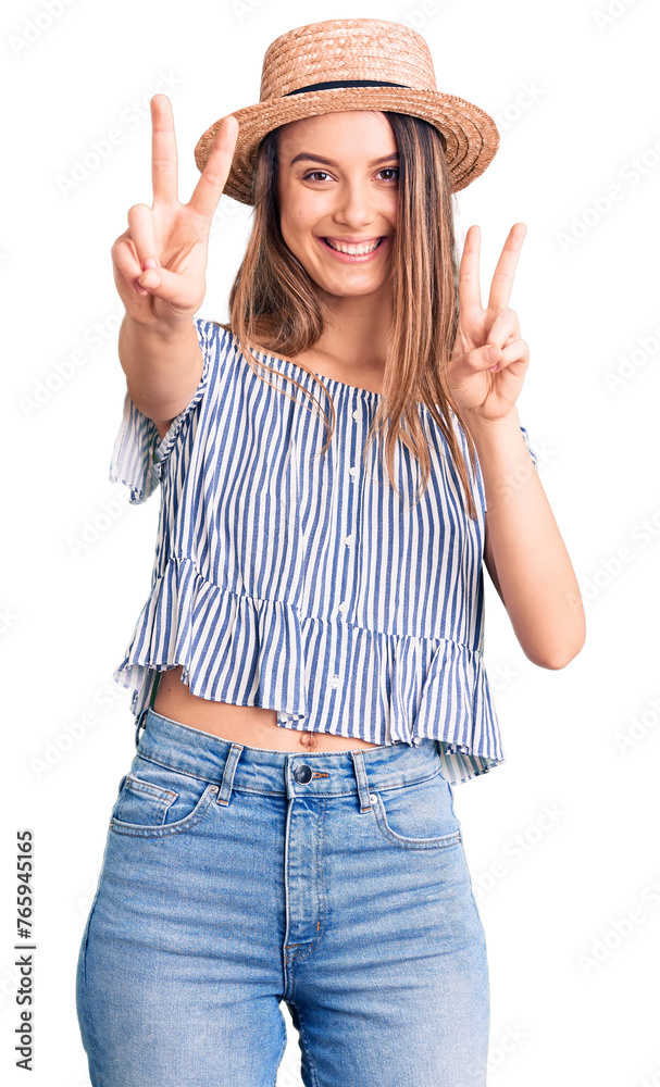 Canvas Prints Young beautiful girl wearing hat and t shirt smiling looking to the camera showing fingers doing victory sign. number two.