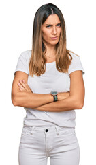 Young woman wearing casual white t shirt skeptic and nervous, disapproving expression on face with crossed arms. negative person.