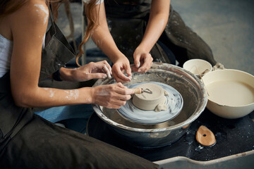 Women's hands potters making ceramic product on the pottery wheel