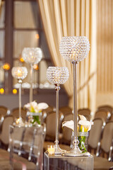 Wedding ceremony decor with white calla lily and glass crystal candle holders