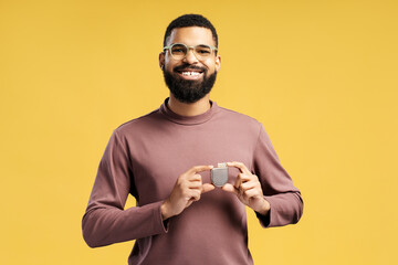 Attractive African American man holding pacemaker looking at camera, cardioverter defibrillator - obrazy, fototapety, plakaty