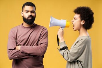 Unhappy couple African American woman holding loudspeaker quarreling shouting. Abusive relationships
