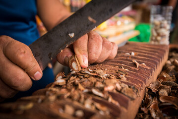 Man Manually Processing Brazilian Nuts From Para With Machete in Ver o Peso Market in Belem City