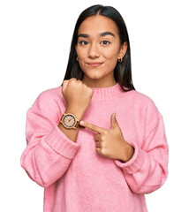 Young asian woman wearing casual winter sweater in hurry pointing to watch time, impatience, looking at the camera with relaxed expression