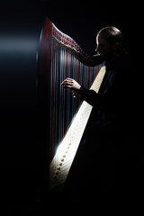 Harp player. Irish harpist playing celtic harp - 765957153