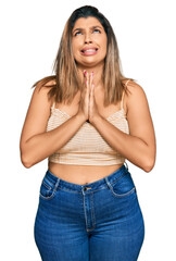 Obraz premium Beautiful brunette woman wearing casual clothes begging and praying with hands together with hope expression on face very emotional and worried. begging.