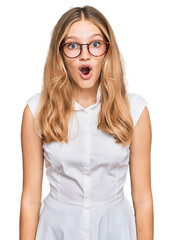 Beautiful young caucasian girl wearing casual clothes and glasses afraid and shocked with surprise expression, fear and excited face.