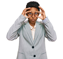 Young african american woman wearing business clothes trying to open eyes with fingers, sleepy and...