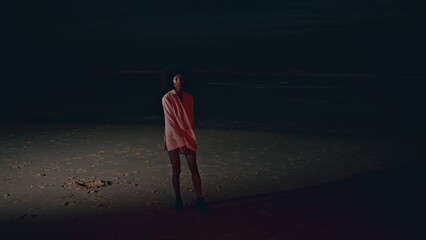 Glamour model stepping shore at night. Stylish african american turning camera