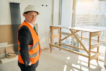 Waist up picture of male architect standing in uncompleted room - obrazy, fototapety, plakaty