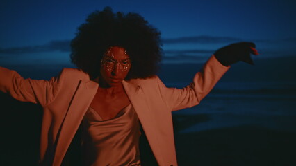 Fashion model dancing dark seashore. Closeup african american spinning night