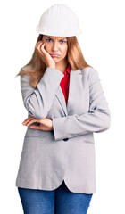 Beautiful young woman wearing architect hardhat thinking looking tired and bored with depression problems with crossed arms.