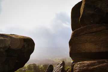 Scenic view of a landscape through rock formations under a cloudy sky at Brimham Rocks, in North...