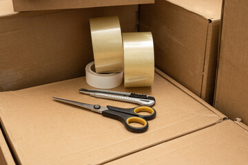 boxes for moving and delivery as well as scotch tape and an office knife with scissors