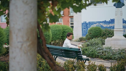 Resting macho holding flower sitting bench alone. Happy man waiting girlfriend