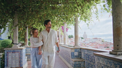 Romantic couple strolling alley. Smiling spouses walking enjoying pleasant date