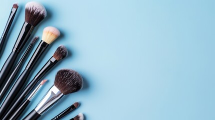 Different makeup brushes with copyspace on a light background - obrazy, fototapety, plakaty