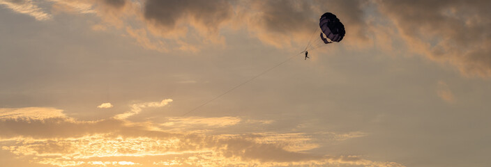 Sunset Soar: Parachute Drifting in the Evening Sky
