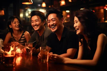 Fotobehang Young men of Asian appearance, partying and drinking at a bar, merrily discussing an interesting topic © EUDPic
