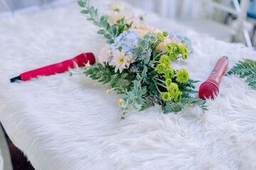 bouquet of flowers and microphone on white feather table