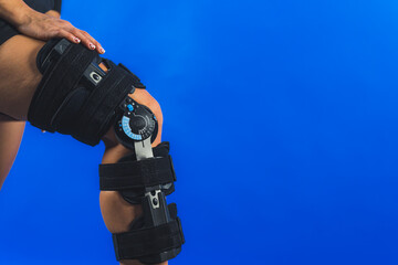 closeup shot of a knee brace with angle movement controler on a leg, medical concept. High quality photo