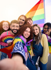 Vertical fun selfie LGBT group young friends celebrating gay pride day together holding rainbow...