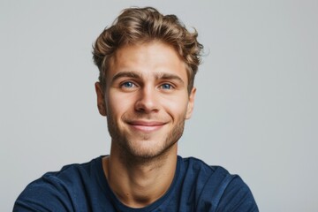 A young man with blue shirt and short hair is smiling - obrazy, fototapety, plakaty