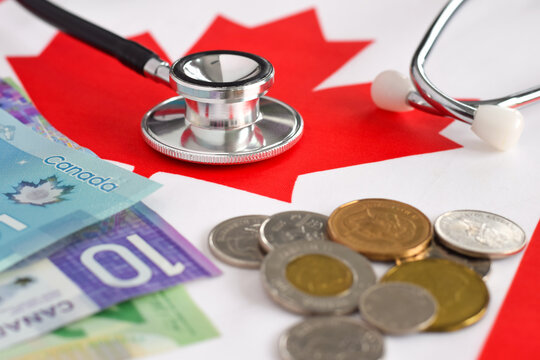 Canada healthcare concept, stethoscope and cash money on top of red maple leaf of Canadian flag