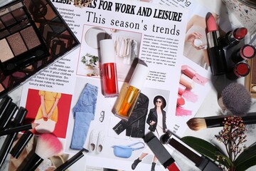 Bright lip glosses among different cosmetic products and fashion magazine on table, flat lay - obrazy, fototapety, plakaty