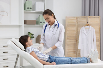 Obraz premium Gastroenterologist examining girl with stomach ache on couch in clinic