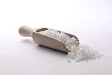 Natural salt in wooden scoop on white background