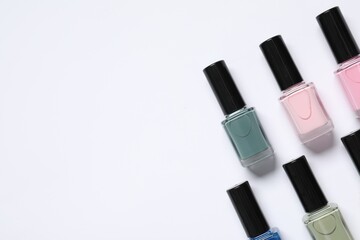 Nail polishes on white background, flat lay. Space for text