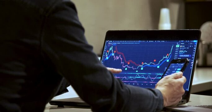 Stepping into a caf&eacute; to escape the hustle and bustle of city life, a man carefully monitors the stock and Bitcoin markets on his computer. 