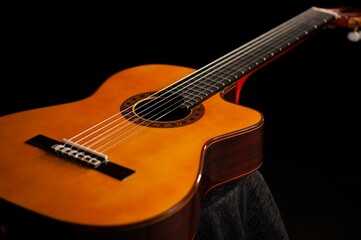 Fototapeta na wymiar Classical Spanish flamenco guitar close up, dramatically lit isolated on black background with copy space.