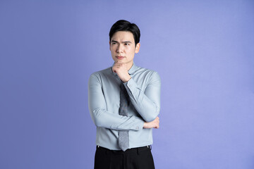 Portrait of Asian male businessman posing on purple background