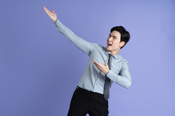 Portrait of Asian male businessman posing on purple background