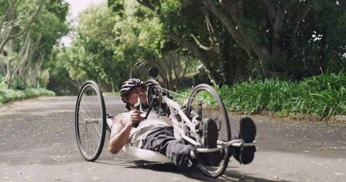 Man, paraplegic and hand riding tricycle in park, forest or road for fitness, health and wellness. People, friends and bike ride of person with a disability in workout, training or outdoor exercise